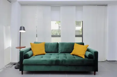 a green couch with yellow pillows in a living room at La Dolce Vita - Your perfect base to explore Rome in Rome