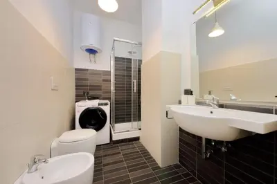 a bathroom with a sink and a toilet and a mirror at La Dolce Vita - Your perfect base to explore Rome in Rome
