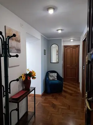 a hallway with a blue couch and a table at DolceCasa - Re di Roma Apartment in Rome