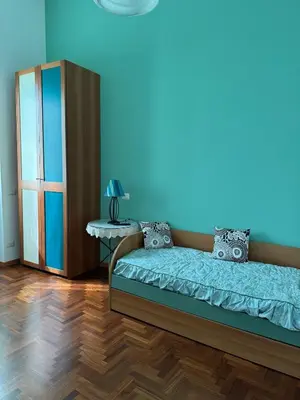 a bedroom with a bed and a blue wall at DolceCasa - Re di Roma Apartment in Rome