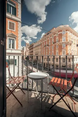 a table and chairs on a balcony with a street at Casa Mia Nazionale in Rome