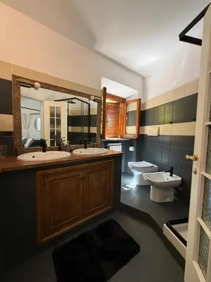 a bathroom with two sinks and a toilet and a mirror at Casa JULIA in Rome