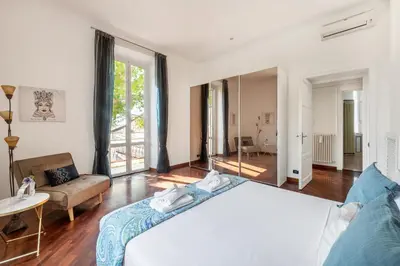 a bedroom with a large bed and a living room at Pigneto House - Residenze Romanae in Rome