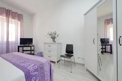 a bedroom with a purple bed and a mirror at Victoria Apartment in Rome