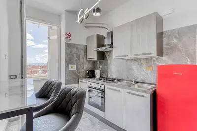 a kitchen with white cabinets and a red refrigerator at ARDECORE VIA VIGEVANO Guest House o Affittacamere in Rome