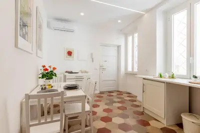 a kitchen with white cabinets and a table and chairs at Top Location - walk to Navona Pantheon and Vatican in Rome