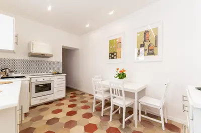 a kitchen with white cabinets and a table and chairs at Top Location - walk to Navona Pantheon and Vatican in Rome
