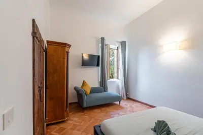 a bedroom with a blue chair and a window at Apartment AppiaAntica in Rome