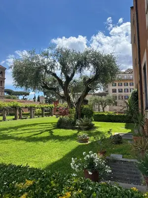 a garden with a tree in the middle of a yard at TreasureRome Forum Terrace in Rome