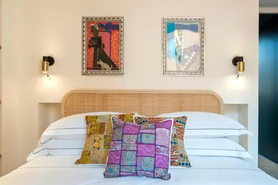 a white bed with pillows and two pictures on the wall at TreasureRome Forum Terrace in Rome