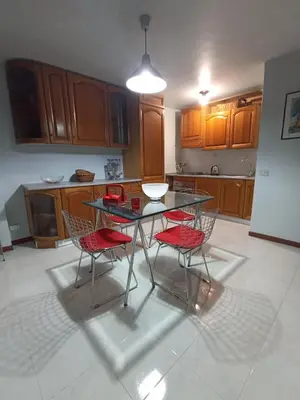 a kitchen with a glass table and two red chairs at casaemily TrenoFiumicinoAir-VillaBonelli-Ostiense in Rome