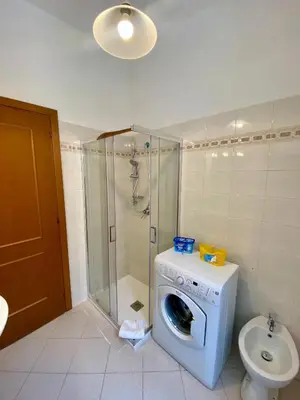 a bathroom with a washing machine and a toilet at Coral Apartment in Rome