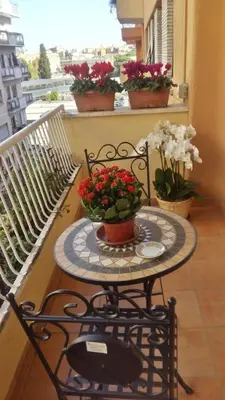 a small table with flowers on a balcony at Le Scalette Al Vaticano B&B in Rome