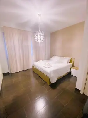 a bedroom with a white bed and a chandelier at Nice flat near Trastevere Station in Rome