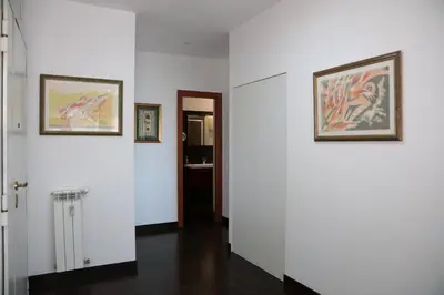 a hallway with white walls and two framed pictures at Nice flat near Trastevere Station in Rome