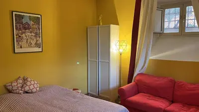 a living room with a red couch and a bed at Villa Sciarra BnB in Rome