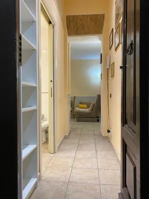 a hallway with a room with a couch and shelves at Family Apartment for five persons in Rome
