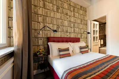 a bedroom with a bed and a wall of books at Maison Evelina in Rome