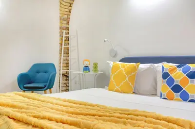 a bedroom with a bed and a blue chair at Il Mattoncino - Colosseo in Rome