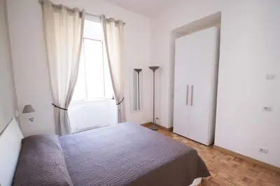 a bedroom with a bed and a large window at Vantaggio Apartment in Rome