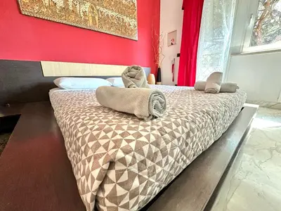 a bed in a room with a red wall at Penthouse Luxe - Rome in Rome