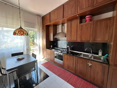 a kitchen with wooden cabinets and a sink and a table at Penthouse Luxe - Rome in Rome