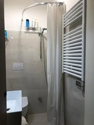 a bathroom with a shower with a toilet and a sink at Trastevere Holiday Home in Rome