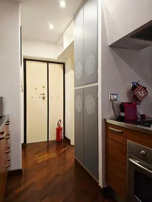 a kitchen with wooden floors and a door to a hallway at Conte Apartment - Roma San Pietro in Rome