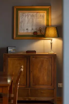 a lamp on top of a wooden cabinet with a picture at Santonofrio SKY Terrace Penthouse in Rome