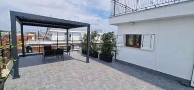 a living room with a green couch and a stool at Nox Romana Apartment - Polyclinic Gemelli - Penthouse with Large Panoramic View Terrace in Rome