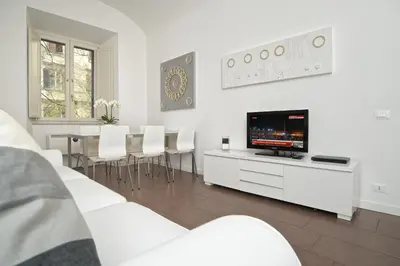 a living room with white furniture and a flat screen tv at Germanico Maxi in Rome