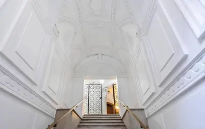 a stairway with a white ceiling and a white staircase at Historic 3BR Colosseum Apartment 160sqm for 9 in Rome