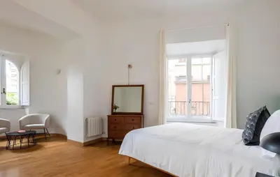 a white bedroom with a bed and a mirror at Historic 3BR Colosseum Apartment 160sqm for 9 in Rome