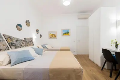 a white bedroom with two beds and a desk at Clio Rome Suite 2 bedroom 2 bathroom apartment in Rome