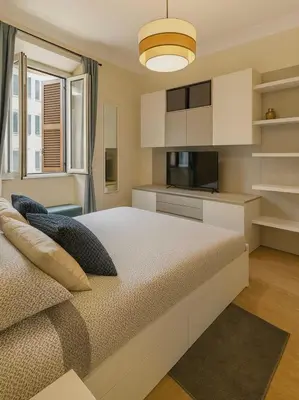 a bedroom with a large bed and a kitchen at Tiepolo La Vie Apartment - Rome Flaminio in Rome