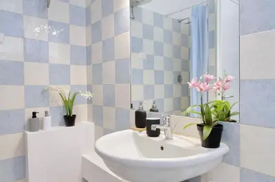 a bathroom with a sink and a mirror and flowers at Domus Sinuessa in Rome