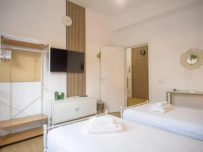 a white room with two beds and a mirror at Relax e Style, Kairos, the house of quality time in Rome