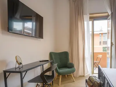 a living room with a green chair and a desk at Relax e Style, Kairos, the house of quality time in Rome