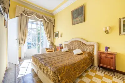a bedroom with a large bed and yellow walls at Residenza Episcopo Lipinsky 1902 in Rome