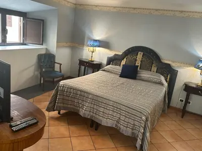 a bedroom with a large bed and a chair at Apt Aurea Domus al Pantheon in Rome