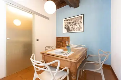 a dining room with a wooden table and white chairs at Pantheon-Rondanini - Cozy Apartment in Rome