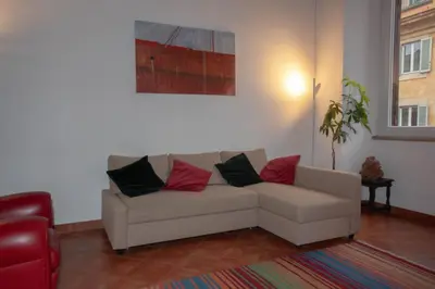 a living room with a white couch with red and black pillows at Pantheon-Rondanini - Cozy Apartment in Rome