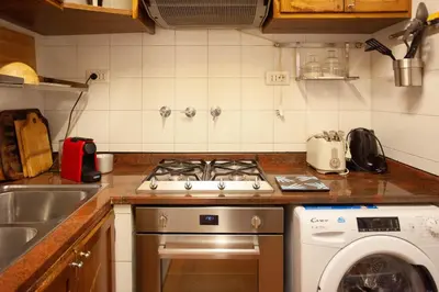 a kitchen with a stove and a washing machine at Pantheon-Rondanini - Cozy Apartment in Rome