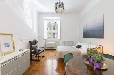 a white bedroom with a bed and a table at Maison Haysée Piazza del Popolo in Rome