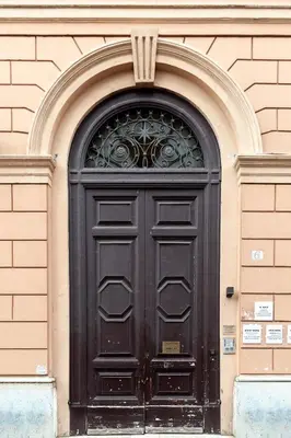 a black door on a building with an arch at IL Sole in Rome