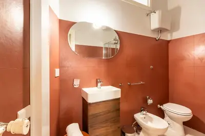 a bathroom with a sink and a toilet and a mirror at Collection39 Scipioni Luxury Apartment in Rome