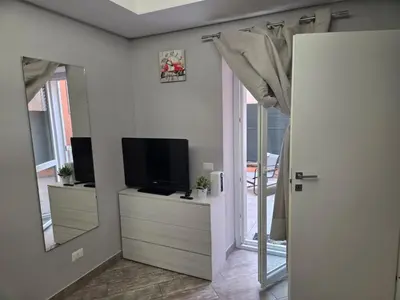 a living room with a television and a mirror at Barbara House Monteverde in Rome
