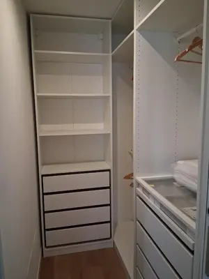 a walk in closet with white walls and white shelves at Golden Suite in Rome