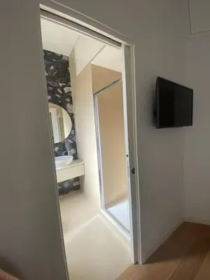 a bathroom with a mirror and a sink and a tv at Golden Suite in Rome