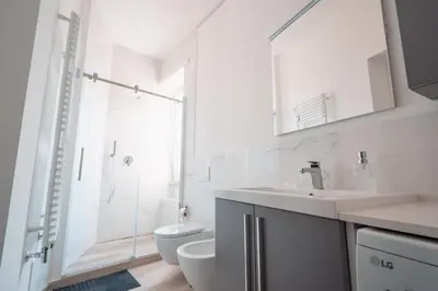 a white bathroom with a sink and a toilet at La Perla dell'Appia in Rome